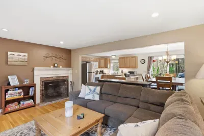 Cozy open living space with fireplace, large sectional, and bright kitchen