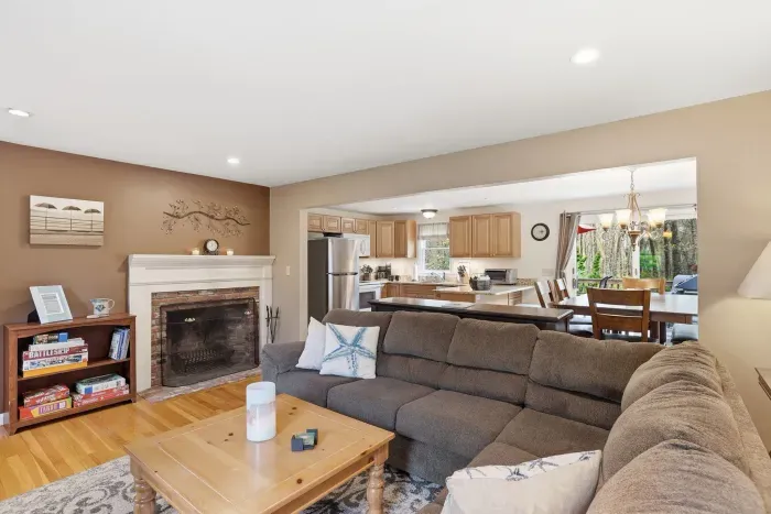 Cozy open living space with fireplace, large sectional, and bright kitchen