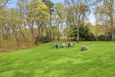 Private wooded backyard with fire pit and spacious lawn for relaxing outdoors