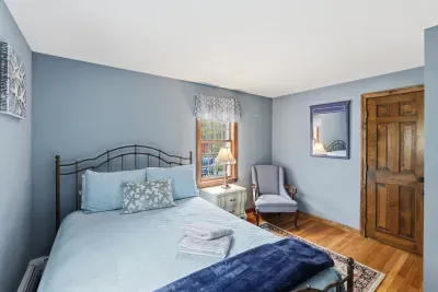 Cozy coastal-inspired bedroom with natural light and hardwood floors