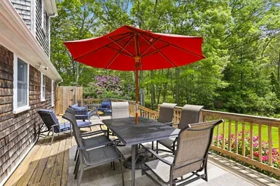 Private wooded deck with outdoor dining and bright umbrella shade