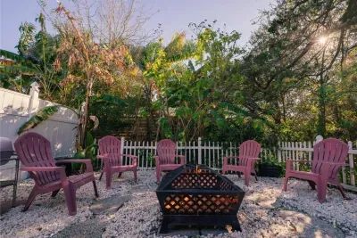 Tropical fire pit lounge with Adirondack seating under lush palms