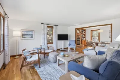 Sunny living room with comfy seating, smart TV, and open dining