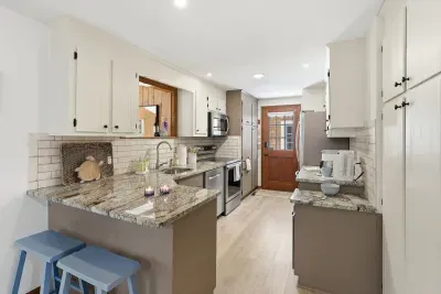 Bright galley kitchen with granite, stainless, and coffee nook