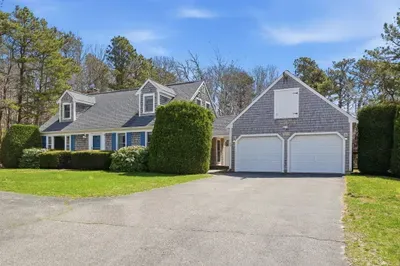Charming Cape with 2-car garage, ample parking & wooded privacy