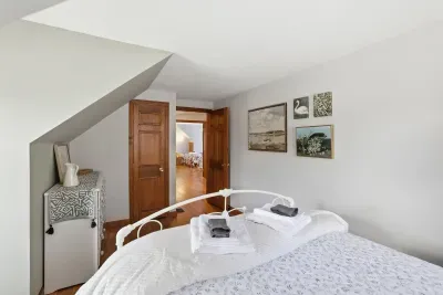 Cozy attic-style bedroom with crisp linens and warm wood accents