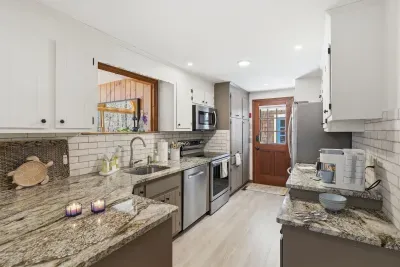 Bright galley kitchen with granite, stainless suite, and coffee bar