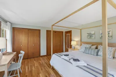 Bright king room with canopy bed, desk, hardwood floors & dual closets