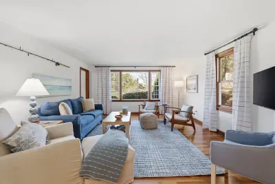 Bright, coastal living room with comfy seating and large picture window.