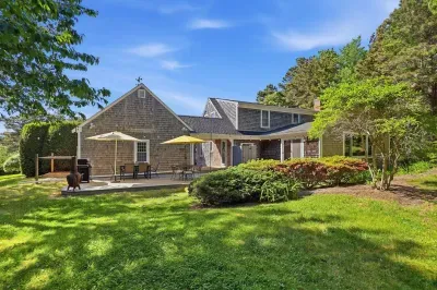 Private backyard oasis with patio dining, grill, and lush green lawn