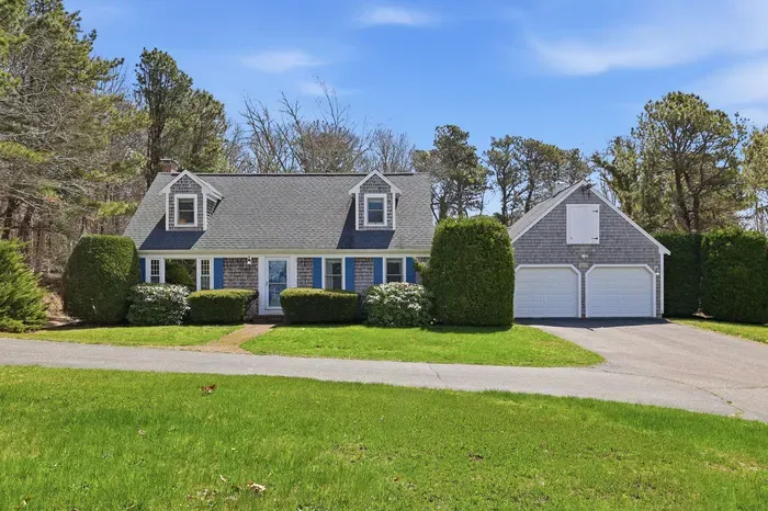 A classic Cape Cod silhouette framed by whispering woods. Pull into the garage, leave the world behind, and let the kids roam free on the sprawling green lawn of your private forest retreat.