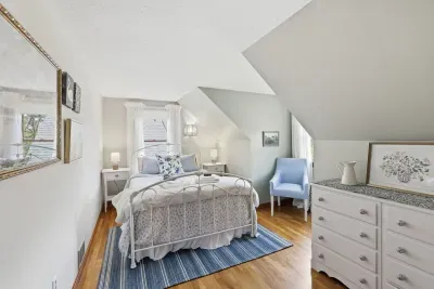 Sunny cottage-style bedroom with cozy nook and hardwood floors