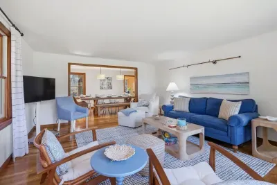 Airy coastal lounge with ample seating, TV, and open dining area.