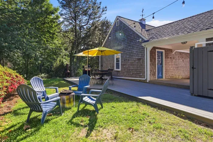 Private backyard deck with fire pit, dining area, and peaceful wooded setting