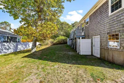 Spacious sunny yard with deck access, shade tree, and picnic table