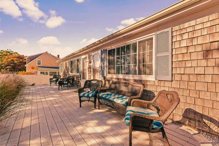 Sunny coastal deck with cushioned wicker seating for lounging