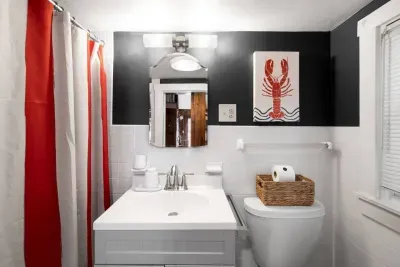 Our full bathroom is here for your convenience. Look at the lobster decorations and the shower curtain's vibrant colors!