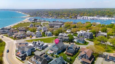 Aerial view of charming coastal home near beach and harbor