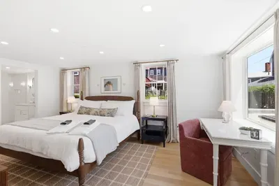 Bright king bedroom with workspace, natural light, and serene coastal style