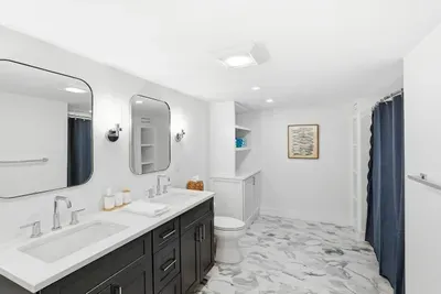 Bright spa-like bathroom with double vanity and elegant marble-look floors