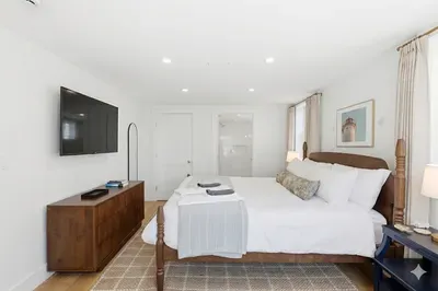 Bright king bedroom with TV, natural light, and a calm modern feel