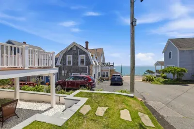Beachside setting with ocean views, deck space, lawn, and easy parking