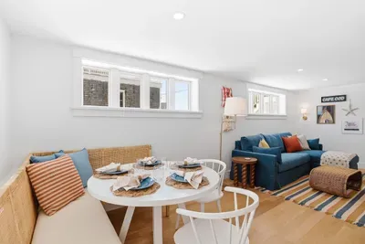 Bright coastal living area with banquette dining and cozy lounge seating