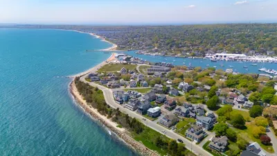 Scenic aerial view of waterfront homes, harbor, and sandy shoreline