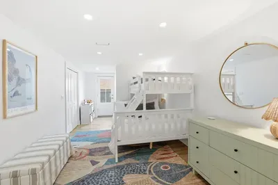 Bright coastal bunk room with stylish storage and cheerful design