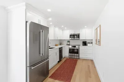Bright modern kitchen with stainless appliances and stylish white cabinetry