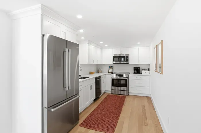 Bright modern kitchen with stainless appliances and stylish white cabinetry