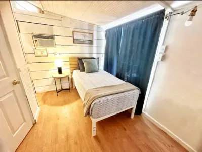 Cozy twin bed with soft bedding and a coastal touch.