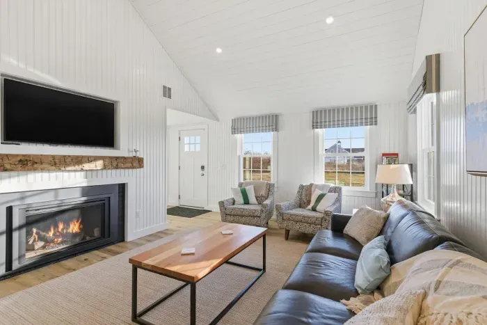 Love the cozy black sofa. Coastal modern done right.