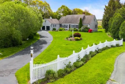 The white fence really stands out, creating a striking contrast with the colorful background house