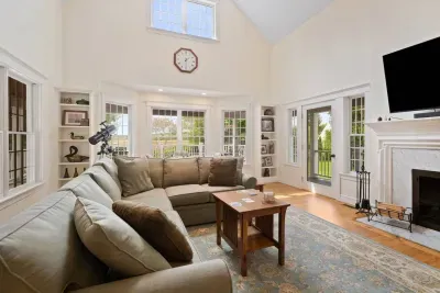 Spacious and bright living area filled with natural light and boasts high ceilings, creating an even grander feel. The oversized couch is perfect for gathering to watch a movie or enjoying the indoor fireplace.