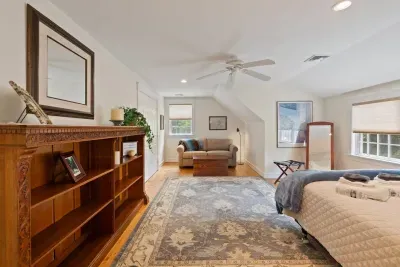 Upstairs, you'll find a spacious room featuring a comfortable queen-size bed and a large sofa