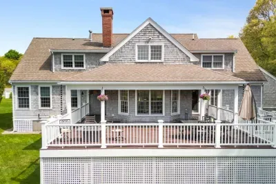 Step out onto the deck and take in the outdoor living area, complete with multiple tables and seating options, a fire pit, and a convenient BBQ grill