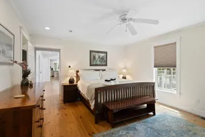 Primary bedroom located on the ground floor with a luxurious king bed and a unique attached greenhouse room – your private oasis awaits!