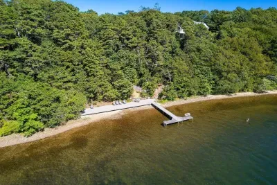 A long, wooden dock extends from the shore into the water.