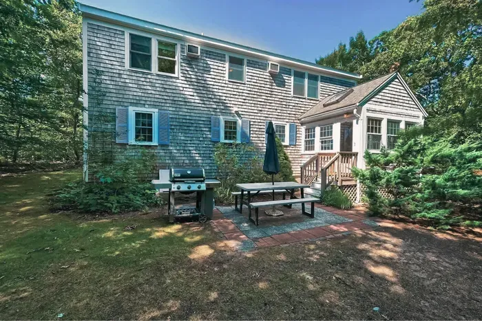 Perfect setup for summer cookouts! Enjoy the spacious patio area complete with a grill, picnic table, and umbrella