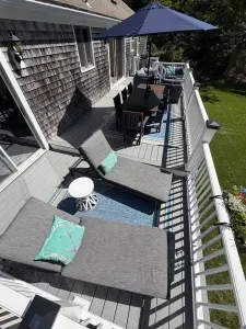 Sunny private deck with loungers, dining area, and peaceful yard views