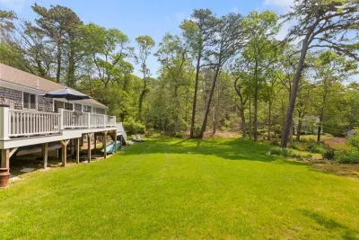 Enjoy summer afternoons on the spacious deck overlooking a massive, manicured lawn bordered by a natural, wooded landscape. Plenty of room for games, relaxation, and family fun