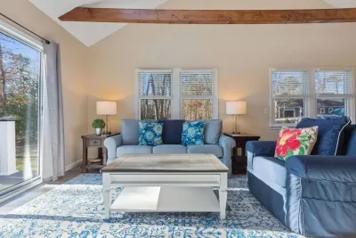 Sunny and serene sunroom with a comfy sofa, TV, and a clear view of the deck

