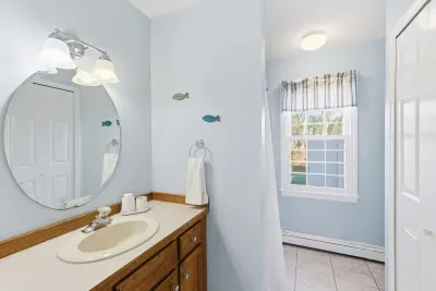 Our light-filled bathroom features soft coastal blues and playful nautical accents, providing a bright and clean spot to get ready for a day on the Cape.