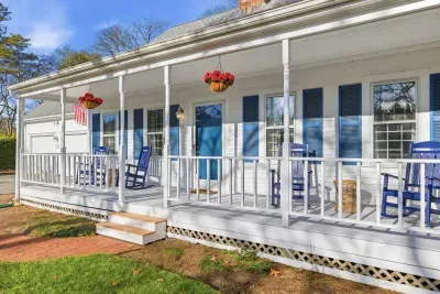 Welcome to your quintessential Harwich retreat, with vibrant blue shutters and a sprawling front porch.