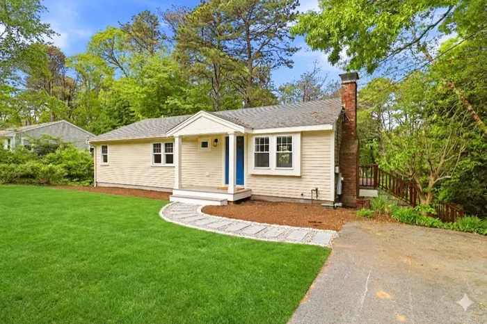 Charming cottage with lush lawn, private setting, and inviting curb appeal