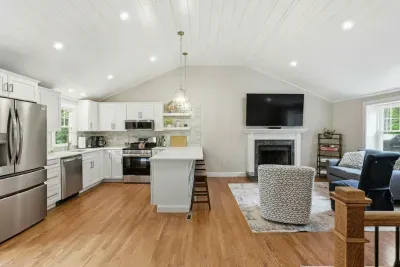 Bright open-concept kitchen and living room with fireplace and island seating