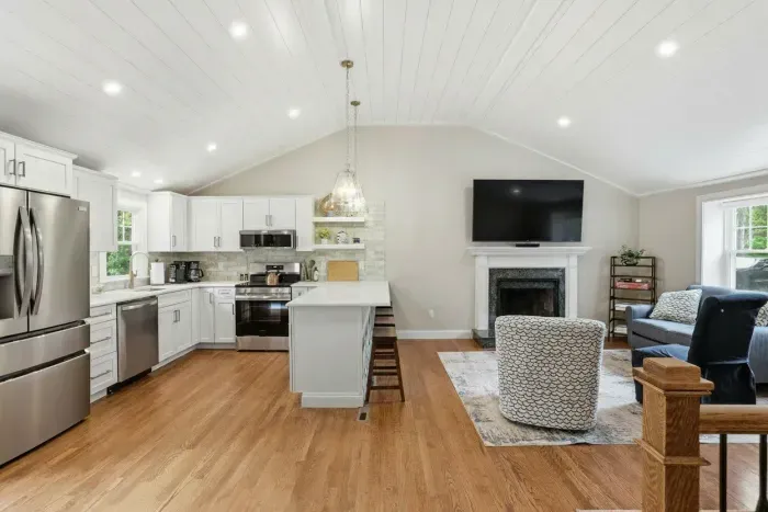 Bright open-concept kitchen and living room with fireplace and island seating