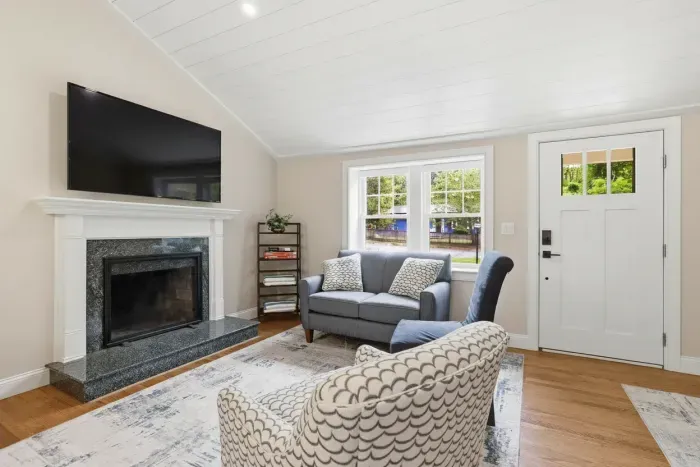 Bright, cozy living room with fireplace, TV, and comfortable seating