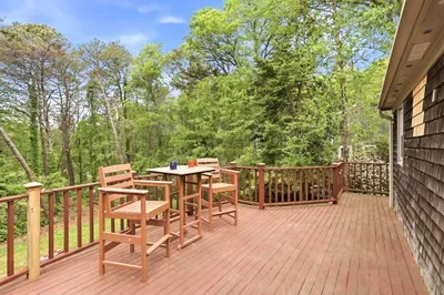 Spacious private deck with wooded views and cozy outdoor seating